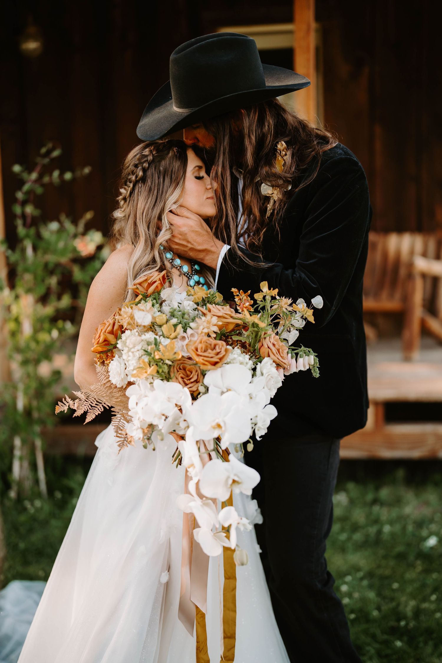 A romantic wedding moment with white and peach floral bouquet against a rustic wooden backdrop.