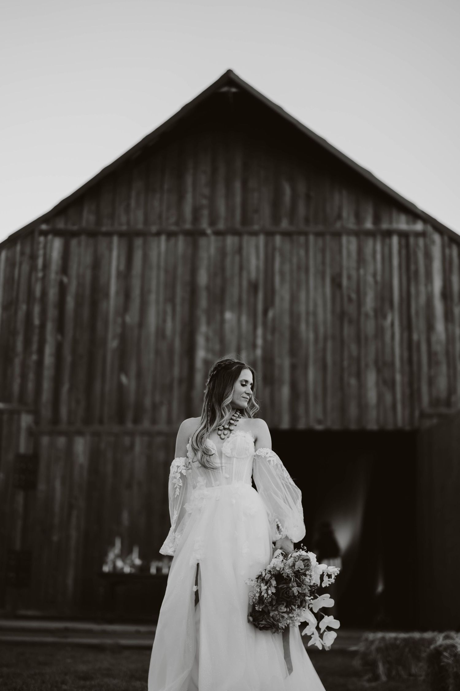 Black and white wedding photography featuring a rustic barn backdrop.