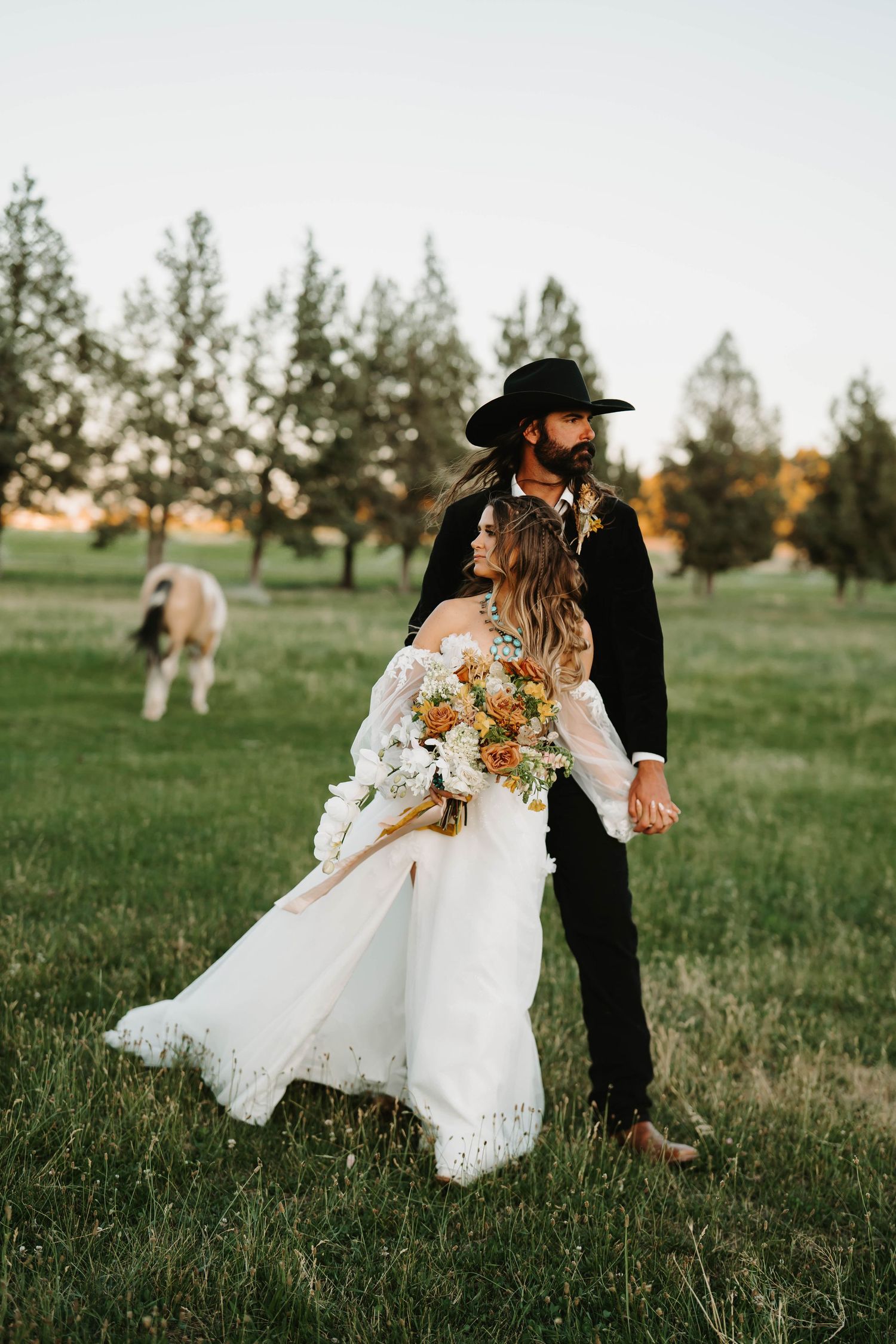 Romantic wedding portraits in a meadow during golden hour.