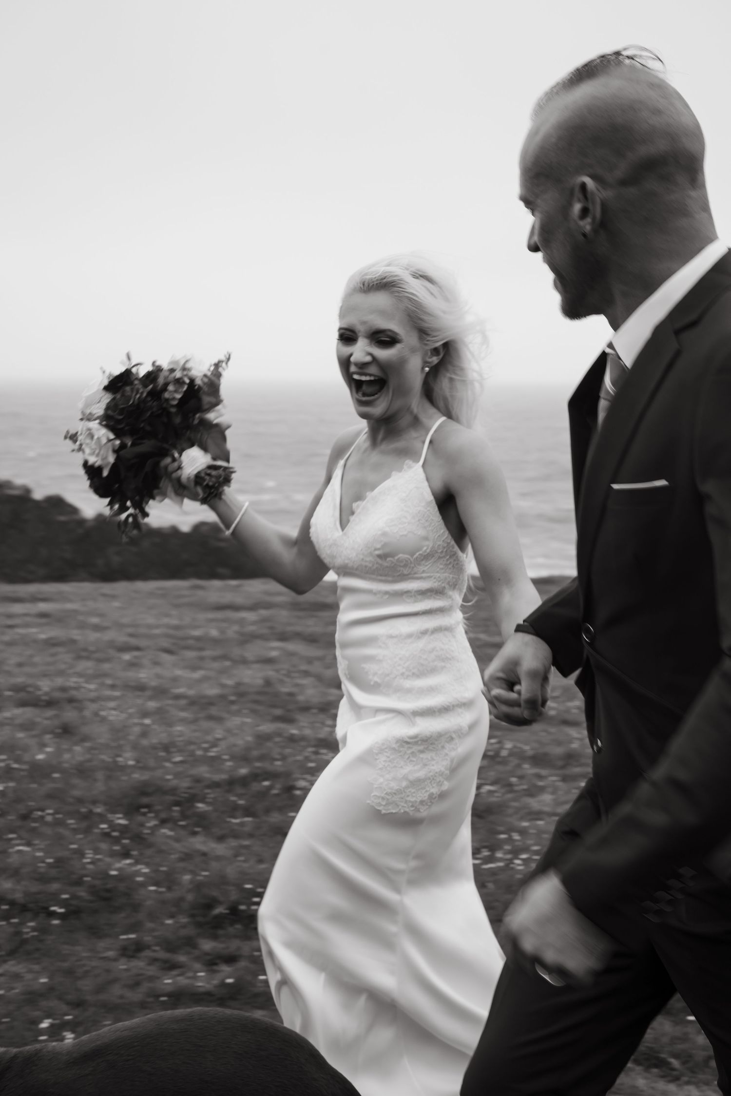Candid moments of bride and groom laughing together on a hilltop.