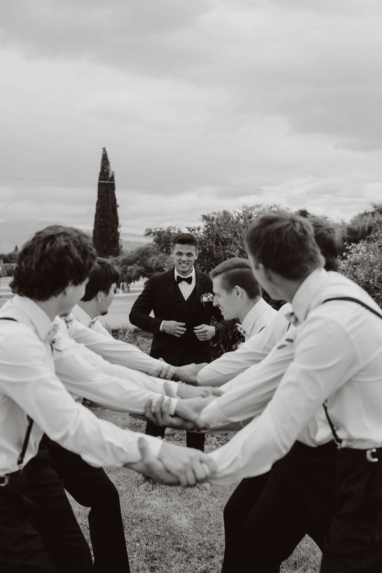 Black and white photo showing playful group interactions outdoors with people in white shirts.