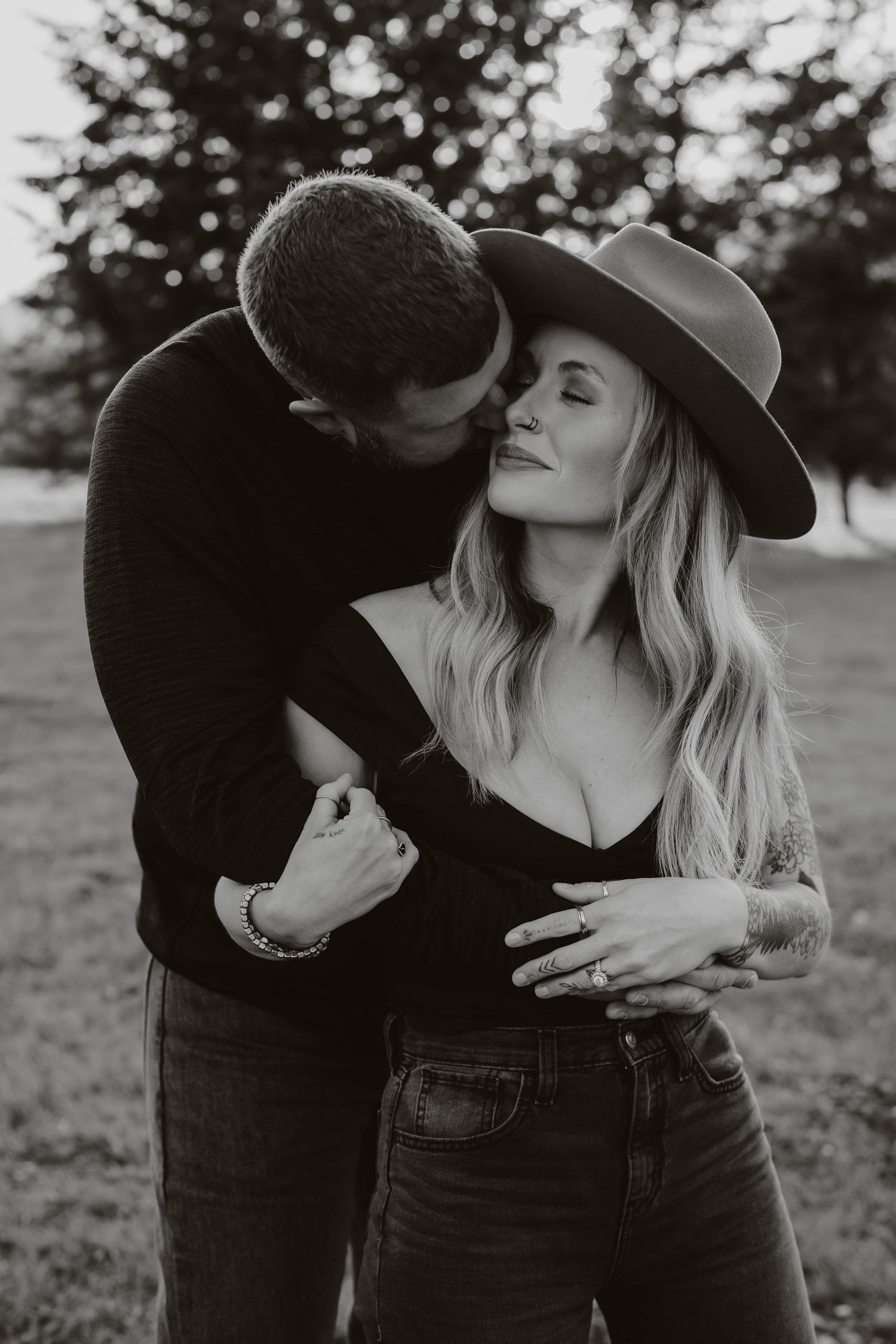 Black and white portrait of intimate couple moment in outdoor setting.