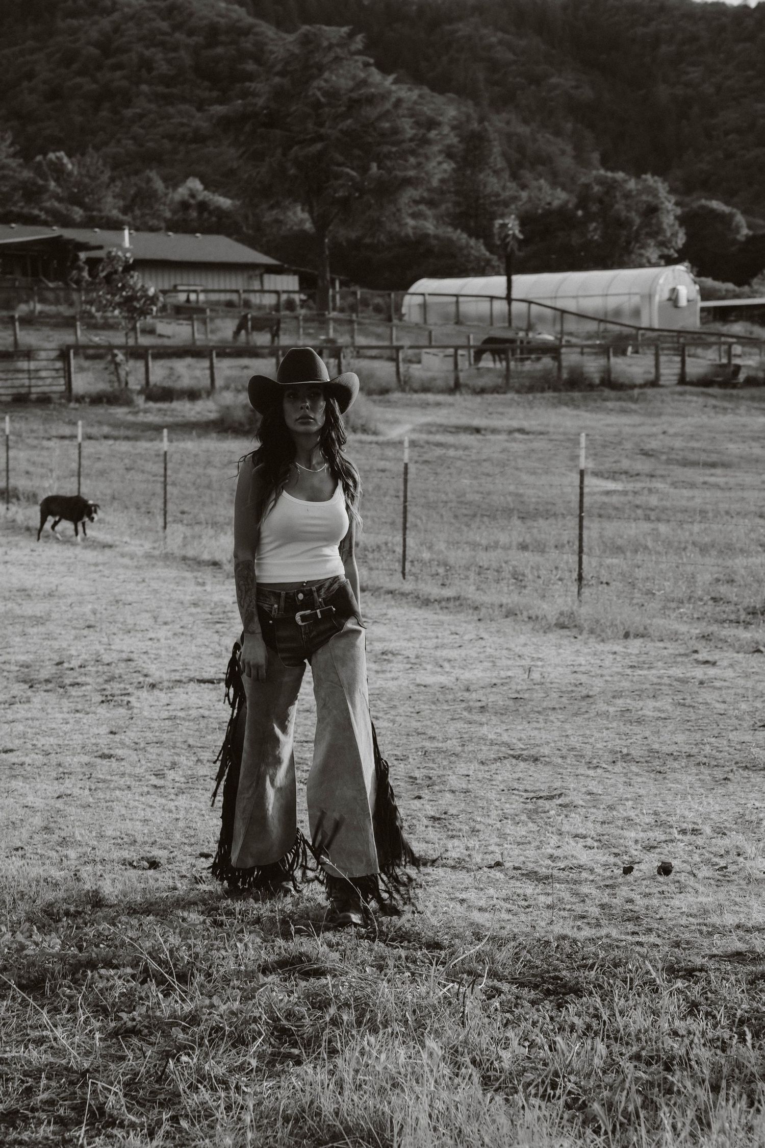Black and white photo of western riders in a rural pasture setting.