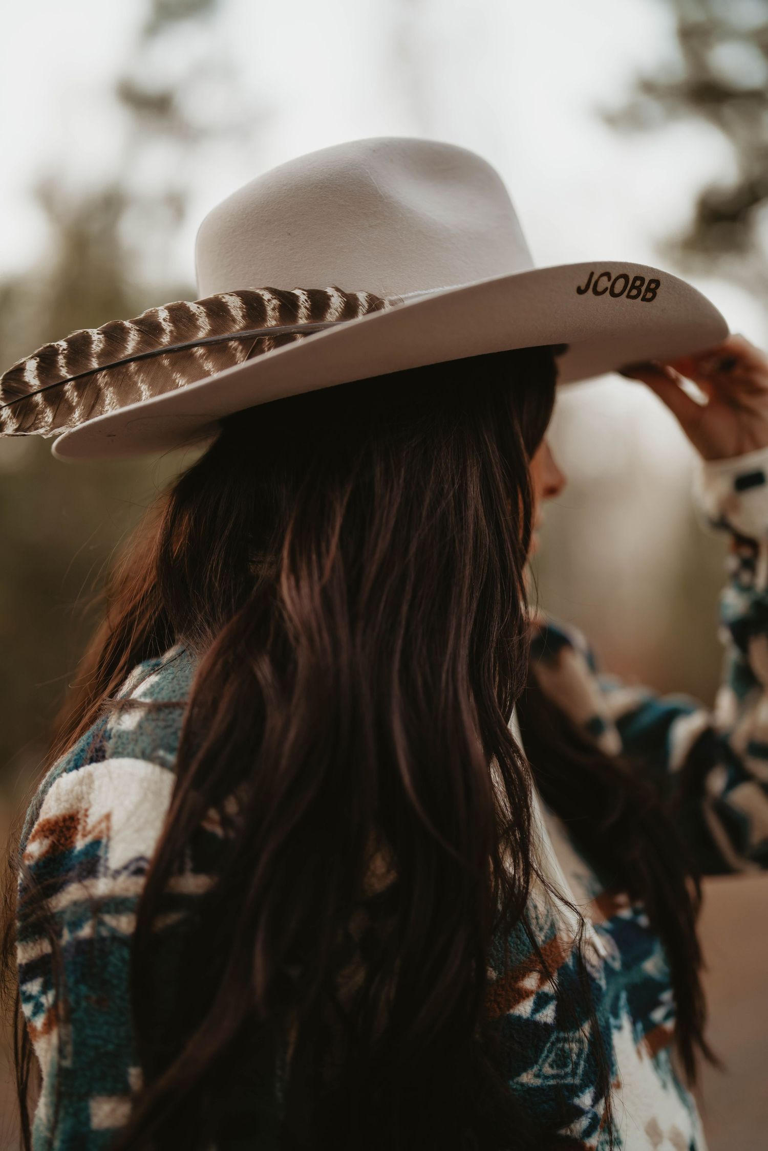 A person wearing a cowboy hat in a sepia-toned close-up shot.