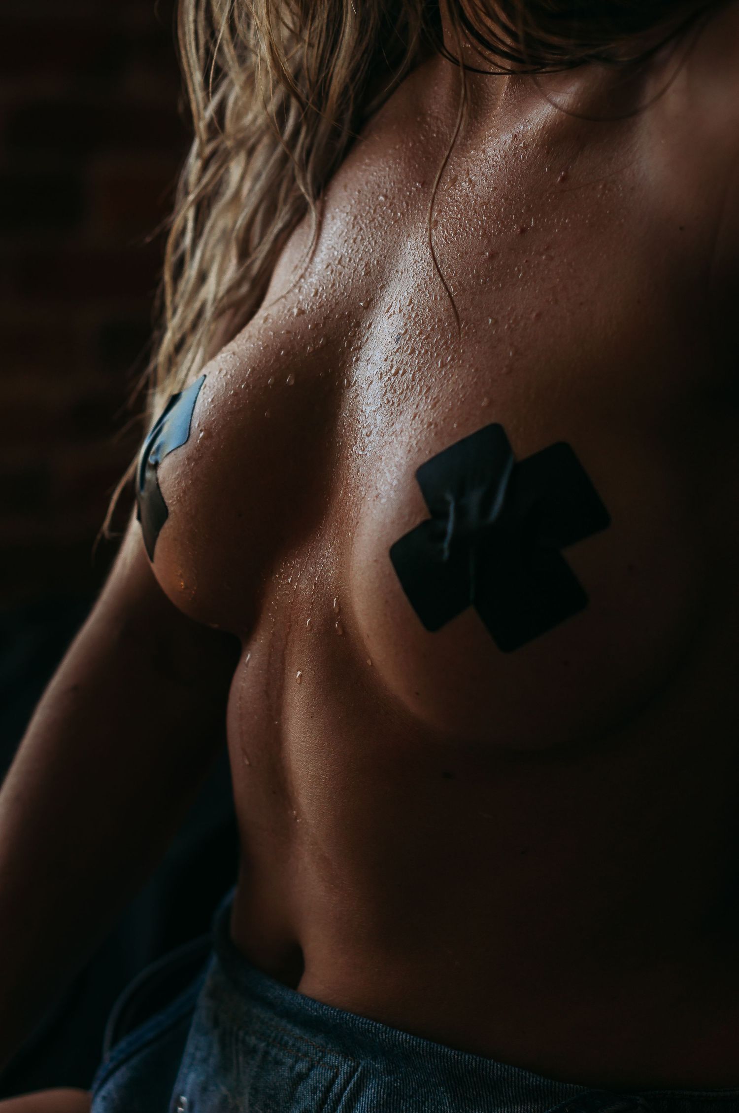 Artistic close-up shots showing skin texture and black tape details.