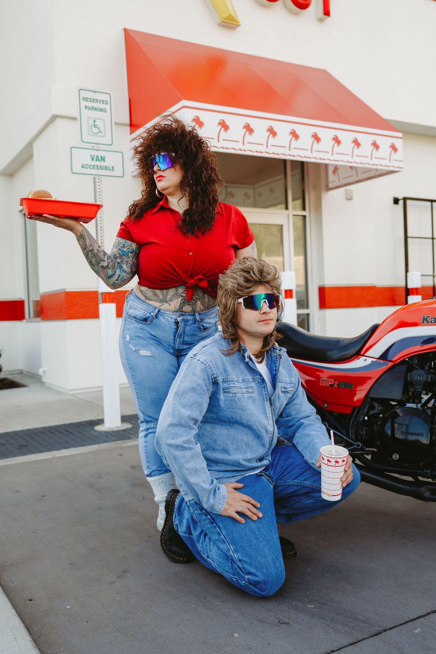 Casual hangout scene outside In-N-Out with motorcycle and drinks.