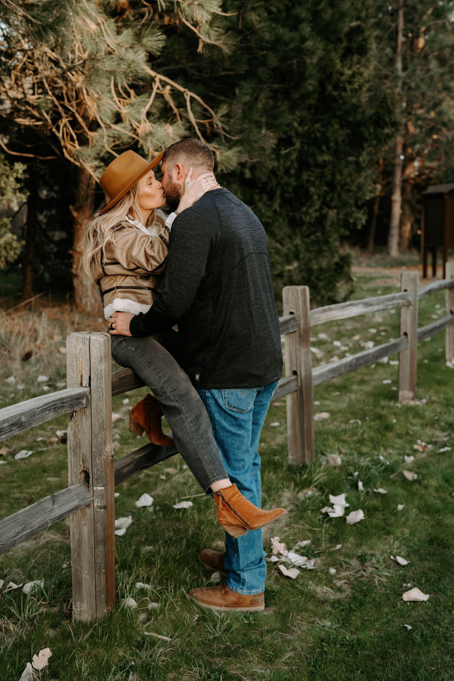 Intimate couple portraits captured along a rustic fence in a natural outdoor setting.