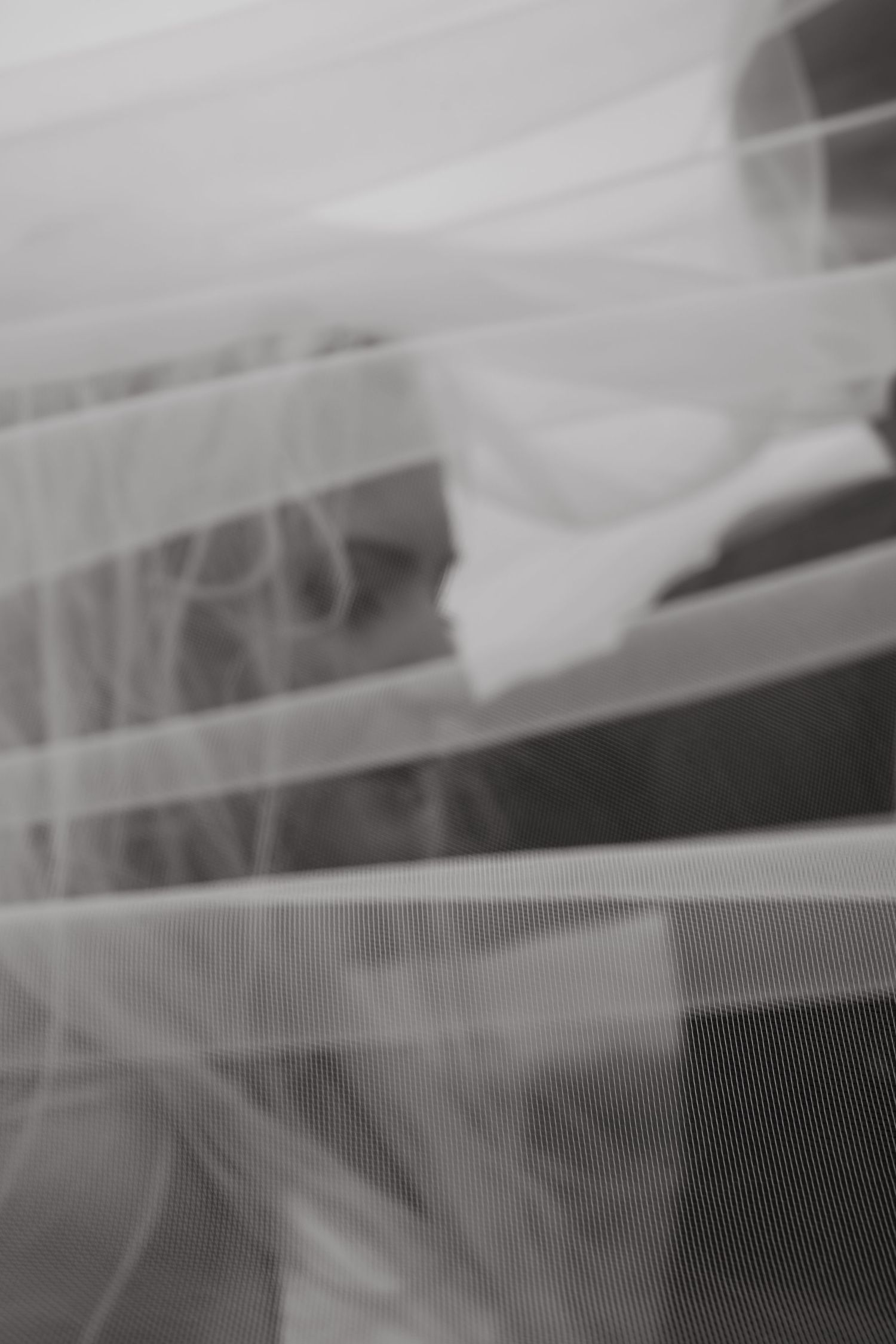 An abstract close-up of flowing white wedding veil fabric.