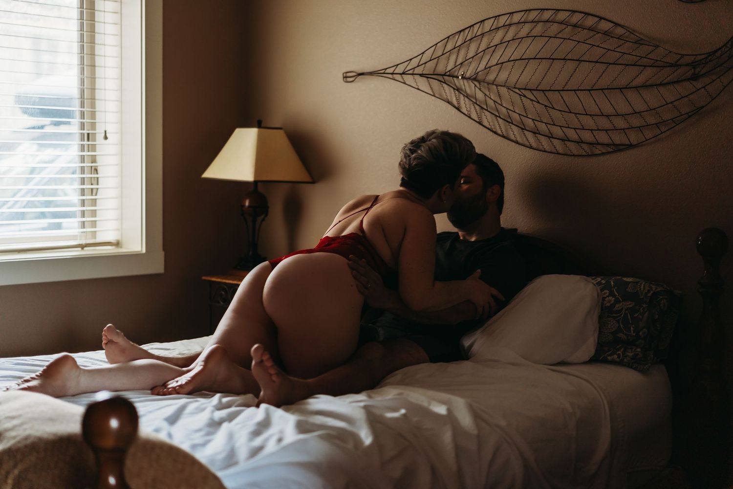 Intimate lifestyle photography session in natural window light on bed.