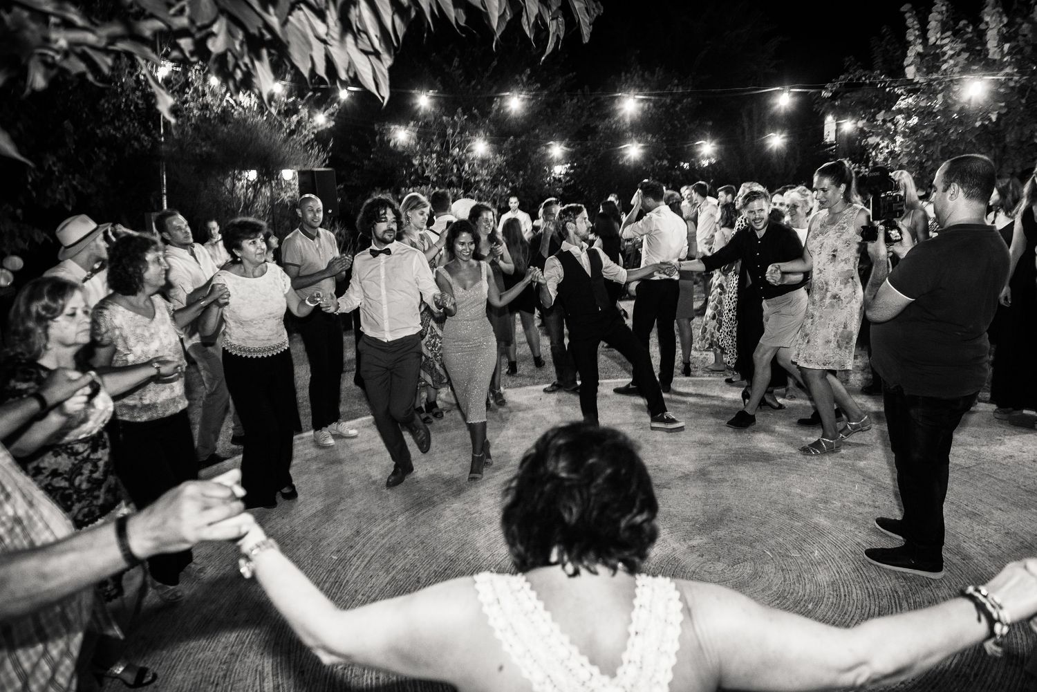 Wedding reception dance floor with string lights creating a festive outdoor atmosphere.