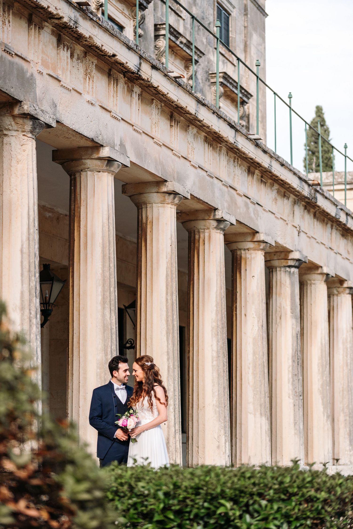 Architectural wedding photos taken against classical stone columns and pillars.