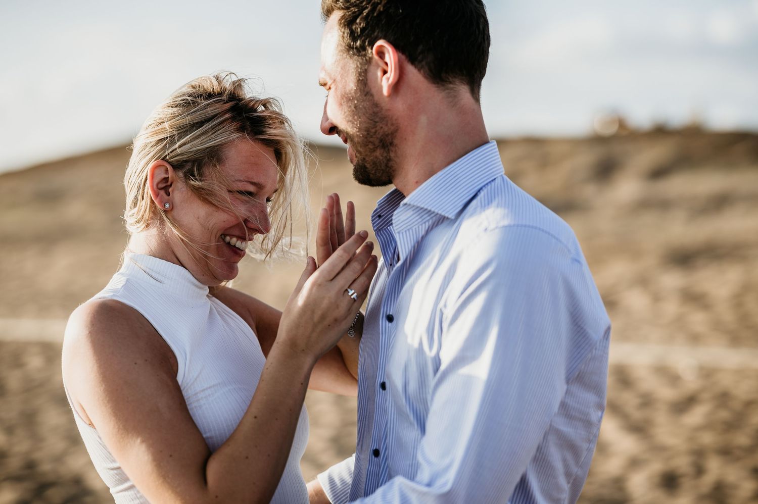 Tender moment shared between a couple in casual beach attire.