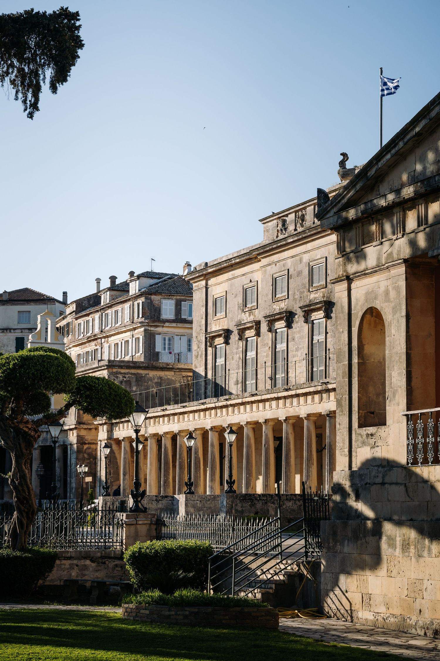 Historic stone colonnade building with classical architecture and arched walkways.