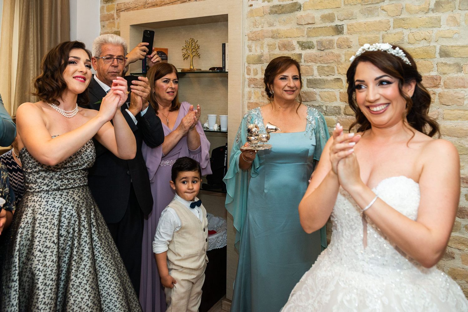 Wedding party members and guests pose together in a celebration space.