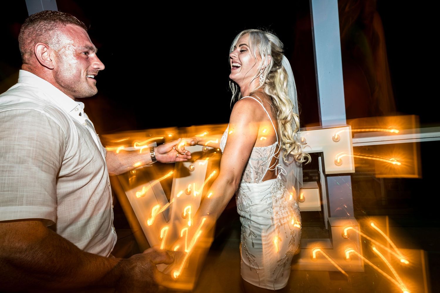 Romantic dance moves illuminated by warm lighting at evening reception.