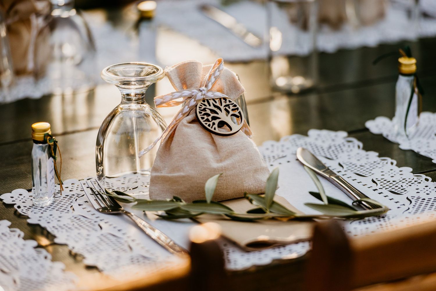 Elegant table setting with glass decanter, silk favor bag, and delicate place settings.