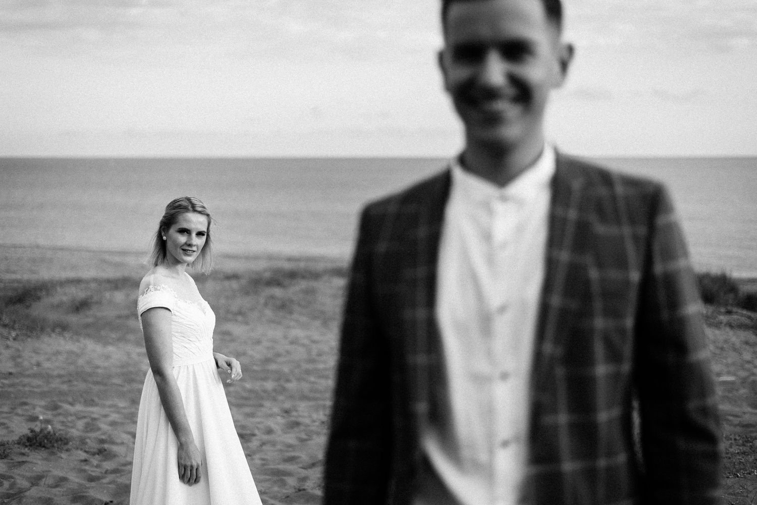 Black and white artistic wedding portraits against dramatic sky.