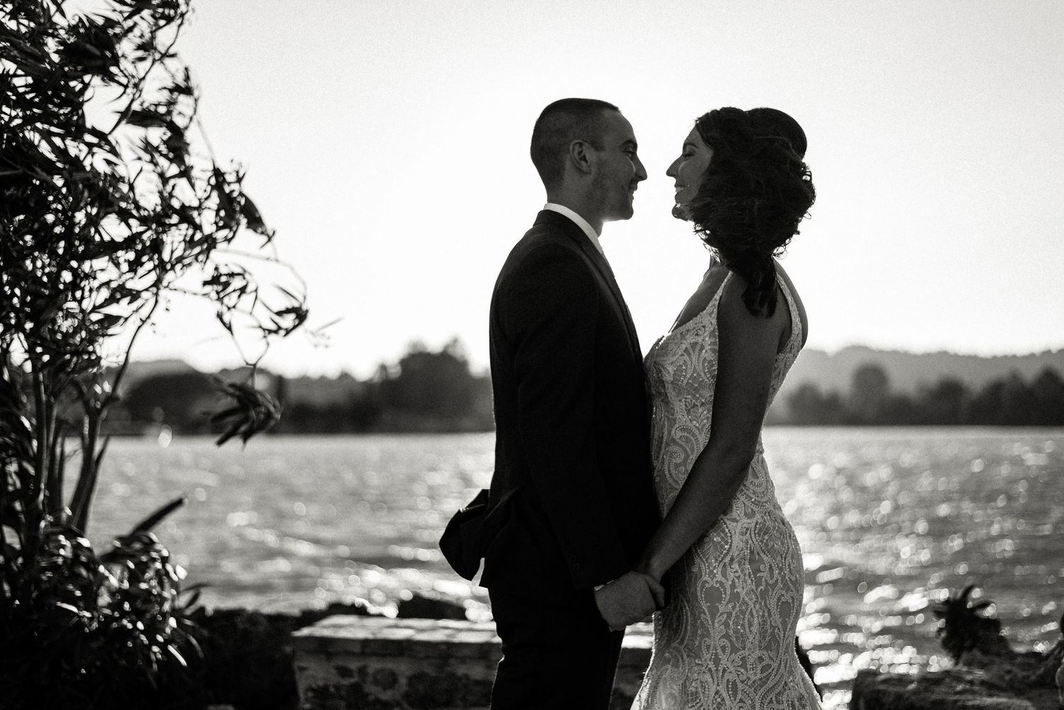 Black and white silhouettes of a couple sharing romantic moments by the water.