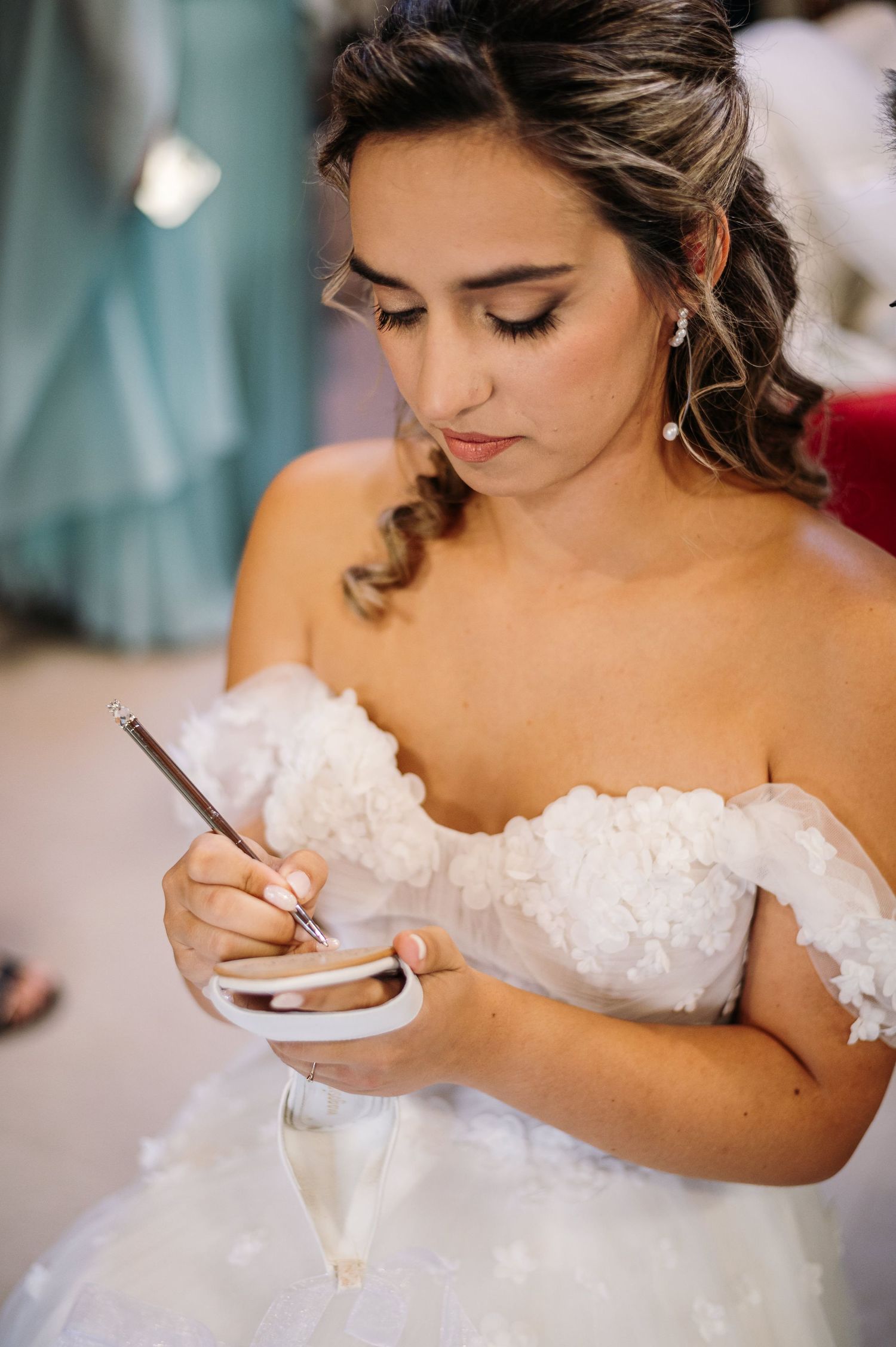 Close-up shots of a bride in a strapless wedding dress writing something before the ceremony.