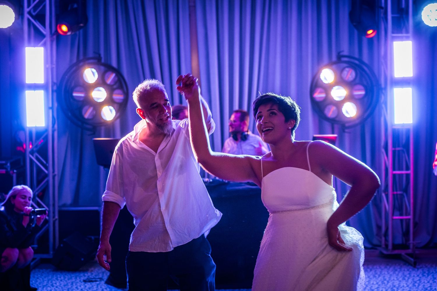 Dance floor lit with blue and purple lights creates atmospheric wedding reception scene.