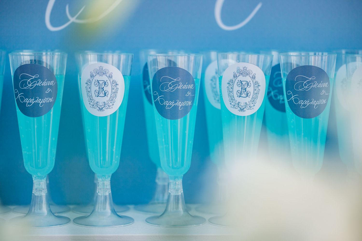 Row of blue tinted glasses arranged for a wedding reception.