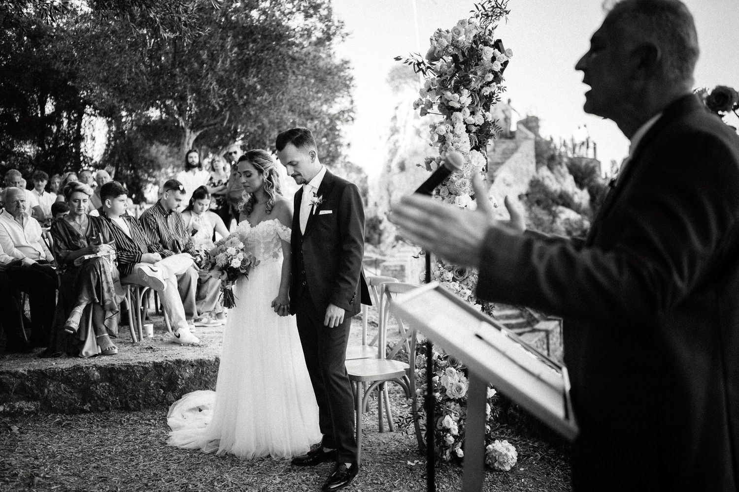 Black and white images of guests celebrating and applauding during an outdoor wedding ceremony.