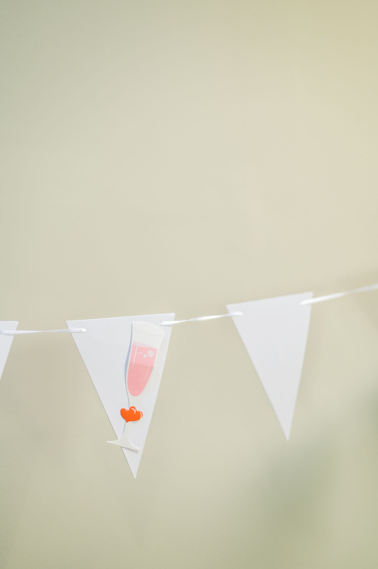 White triangle bunting flags hanging against a soft neutral background.