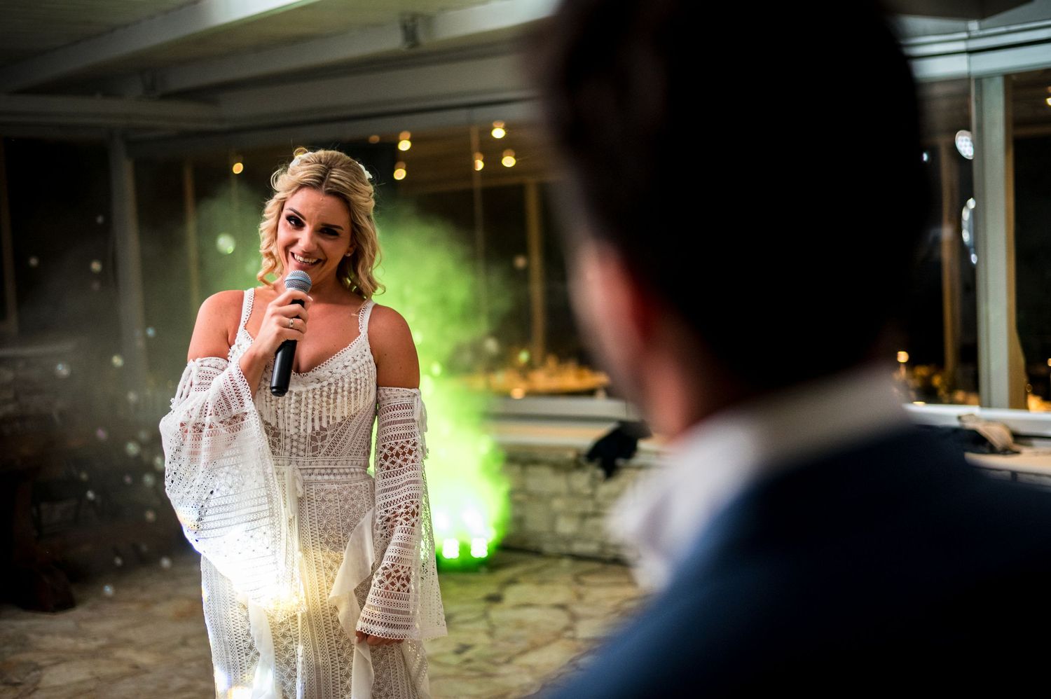 Wedding reception speech moment with soft lighting and bokeh effects in the background.