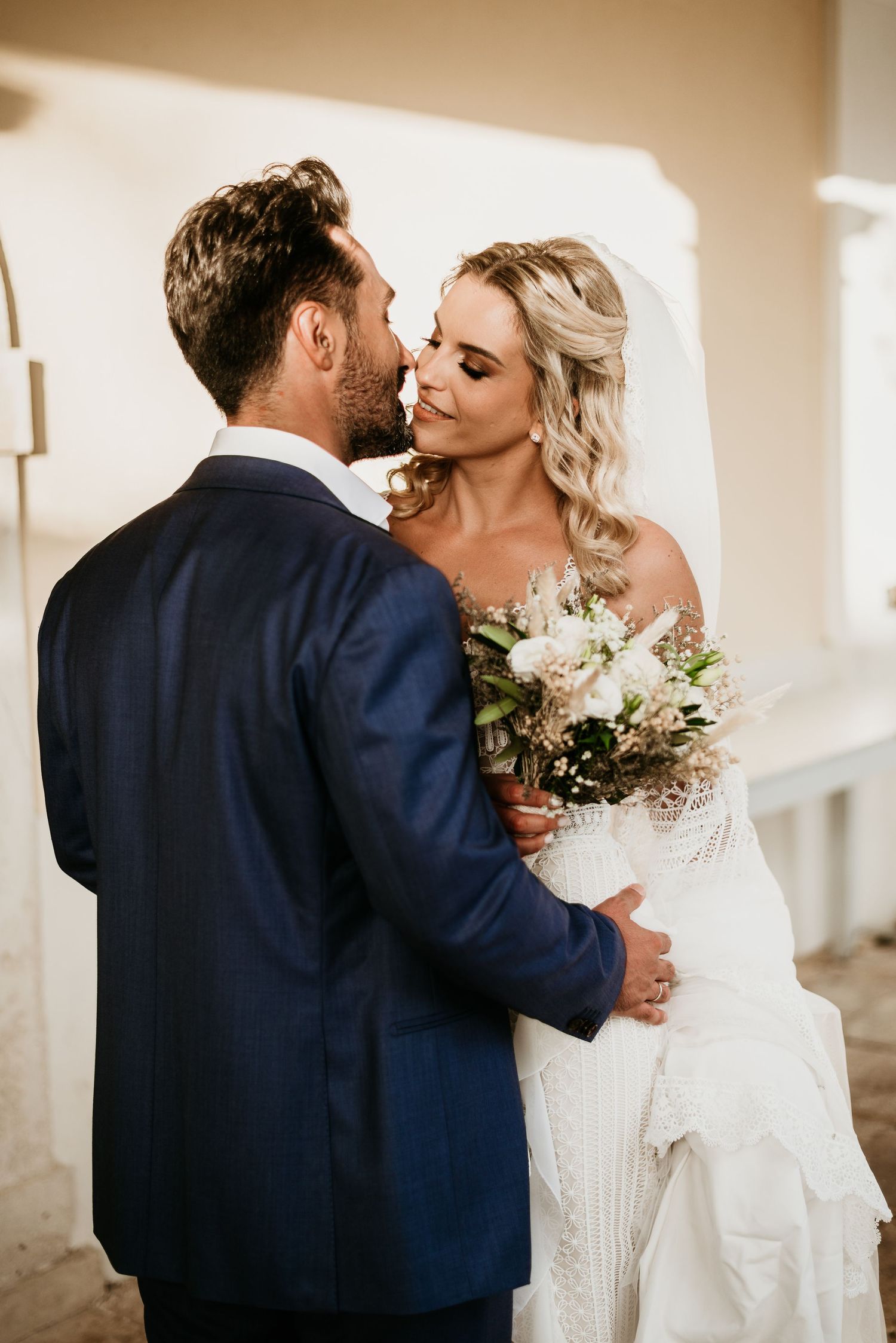 Intimate wedding moment captured against neutral background.