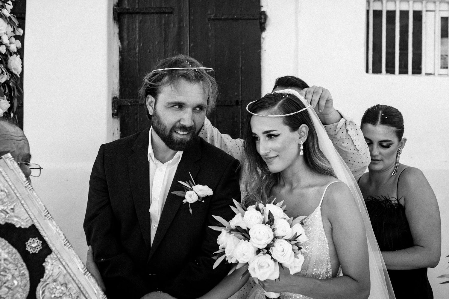 Black and white photo of wedding party members sharing emotional moments together.