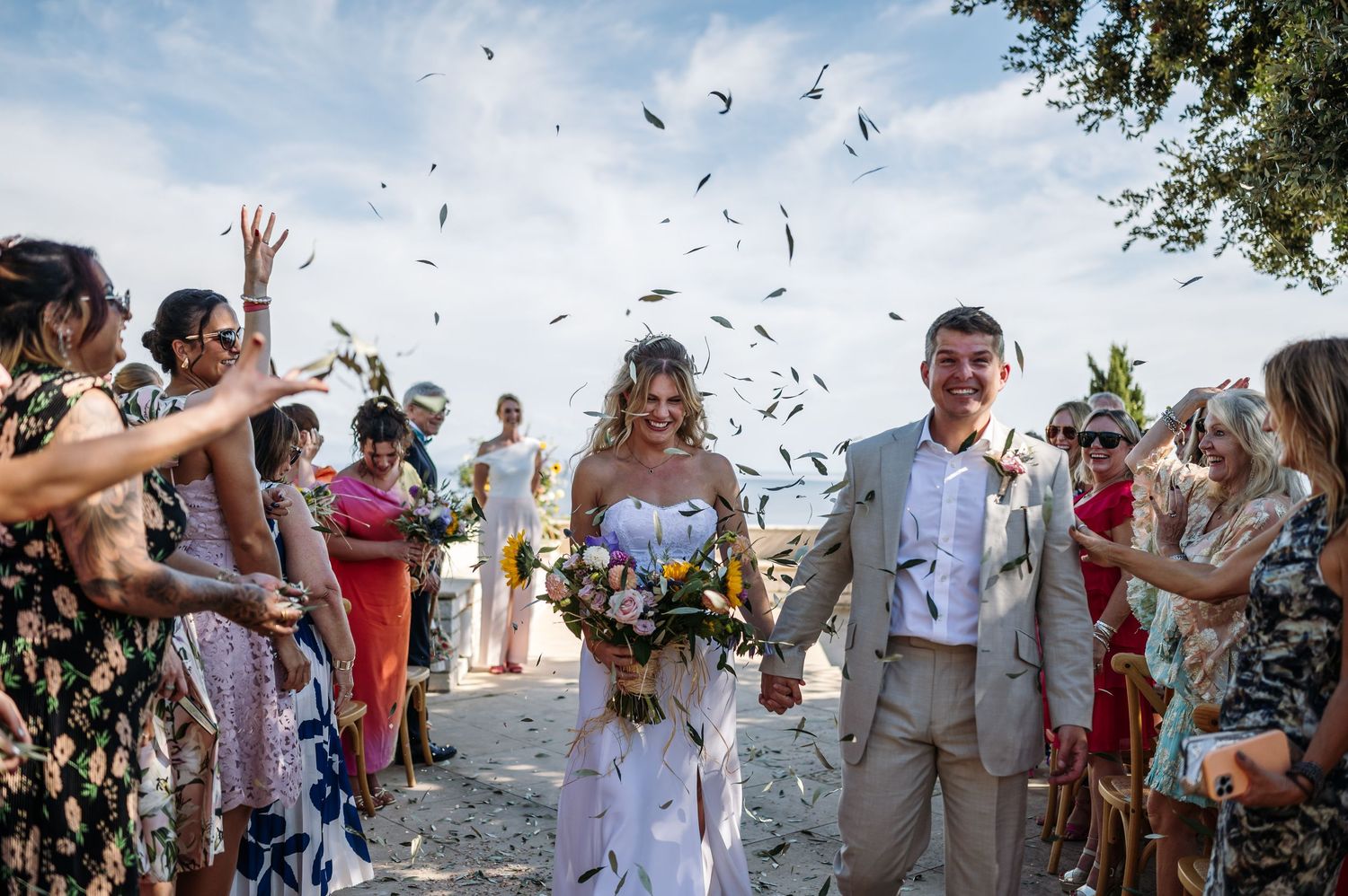 Confetti fills the air as wedding guests celebrate the newlyweds.