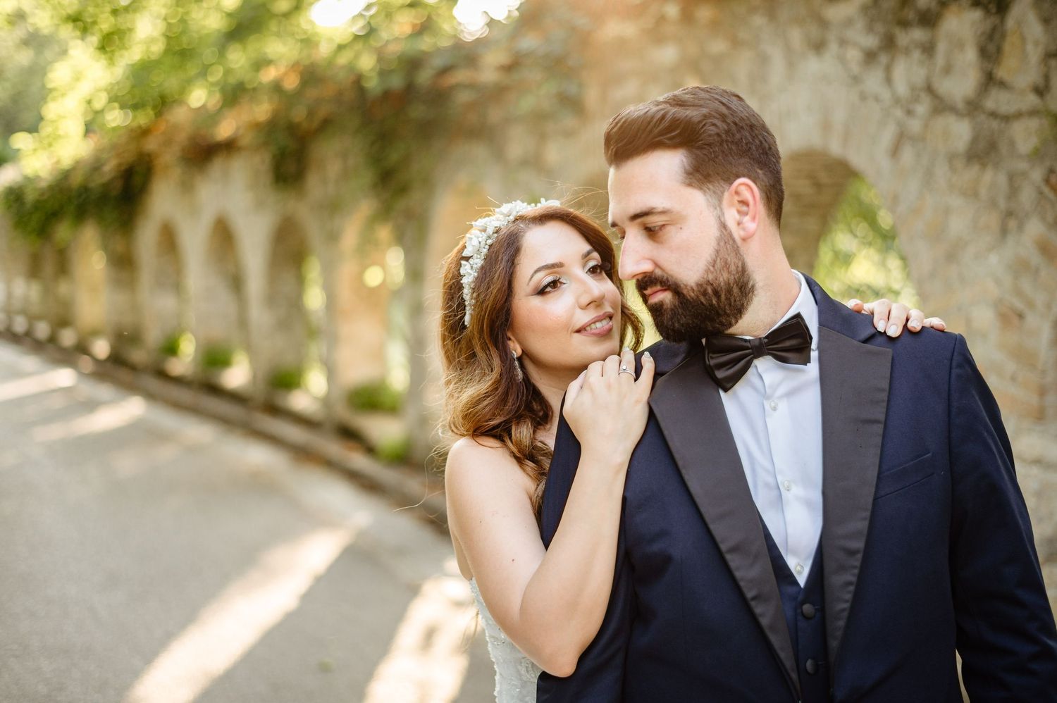 Intimate wedding couple portraits against a rustic stone wall backdrop.