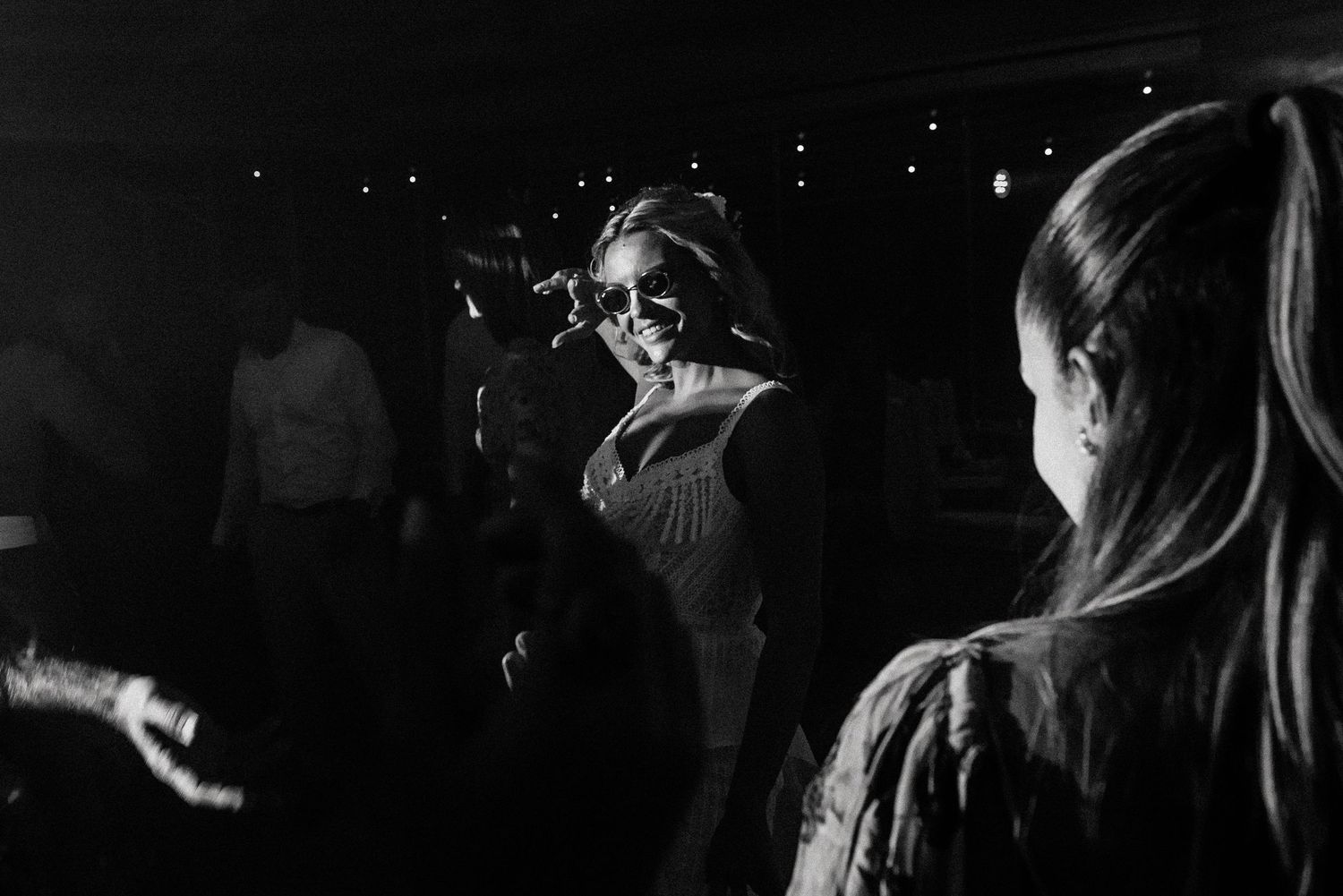 Dark and moody dance floor scene with silhouettes of party guests.