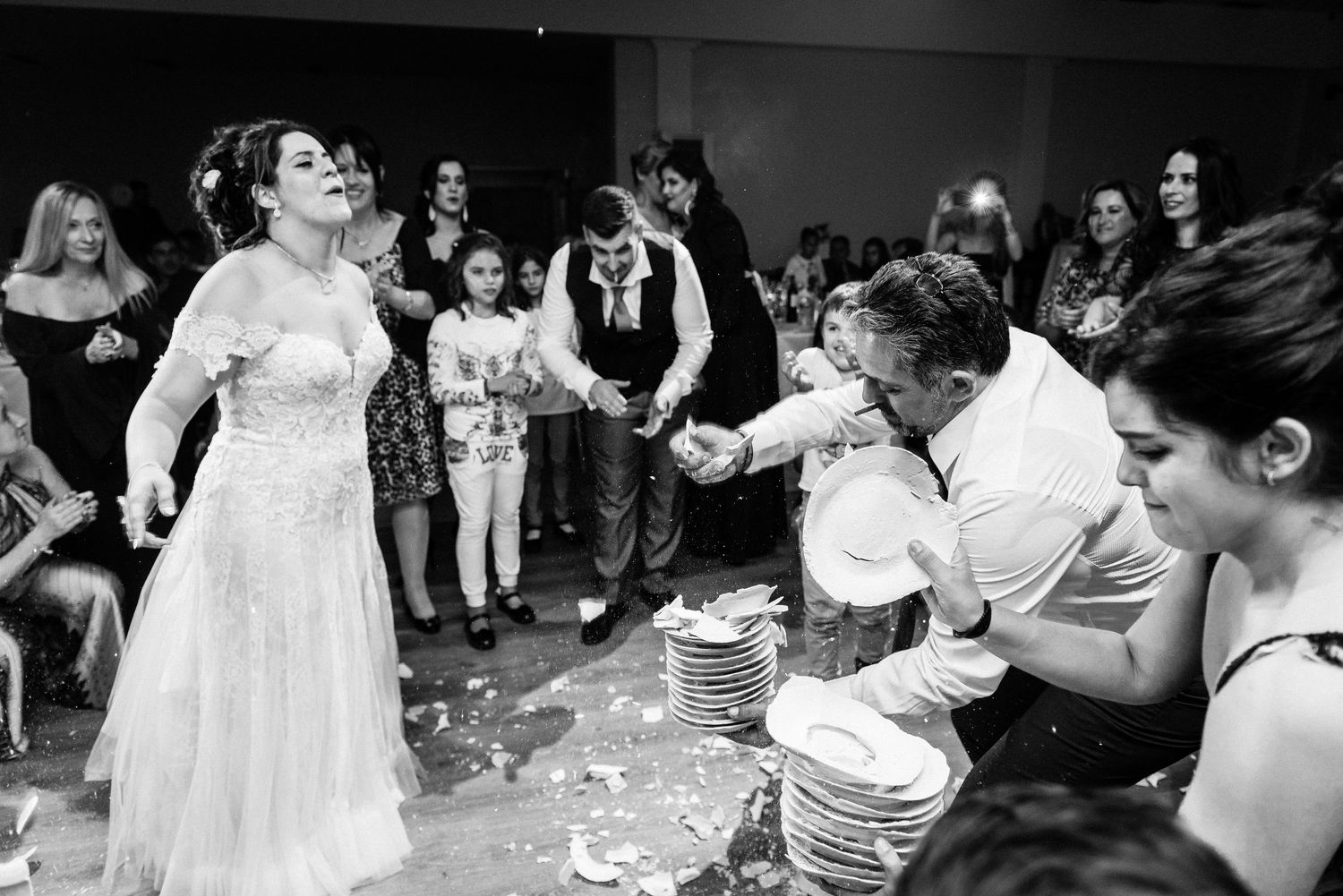 Black and white photos of people dancing and celebrating at a lively wedding reception.
