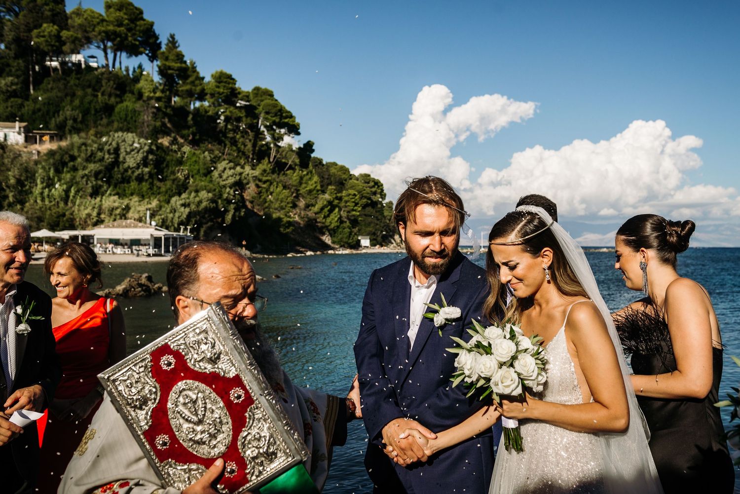 Seaside wedding celebration with palm trees and ocean views in the background.