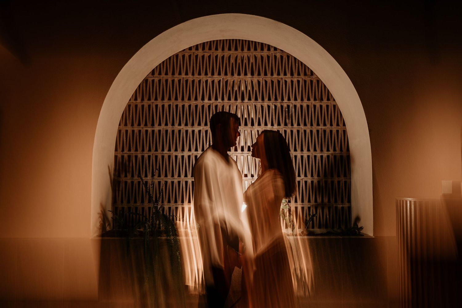 Artistic silhouettes through an arched doorway creating a romantic atmosphere.