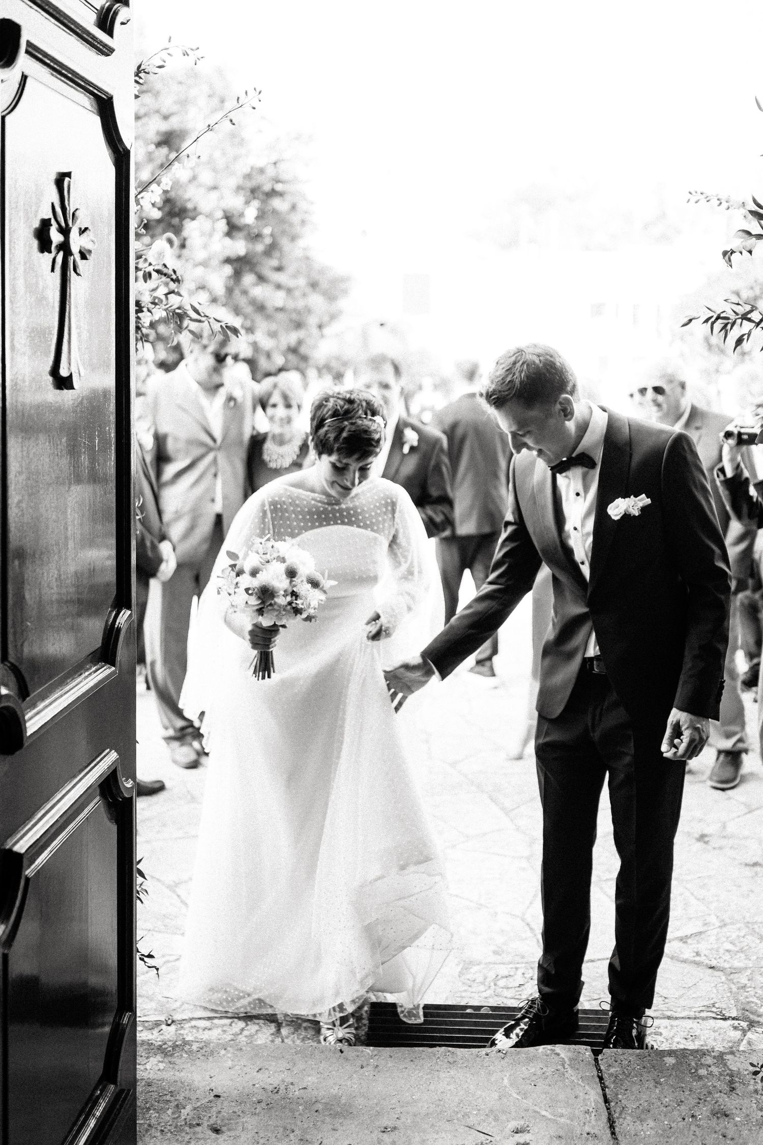 Black and white series showing wedding couple and guests entering through ornate doorways.