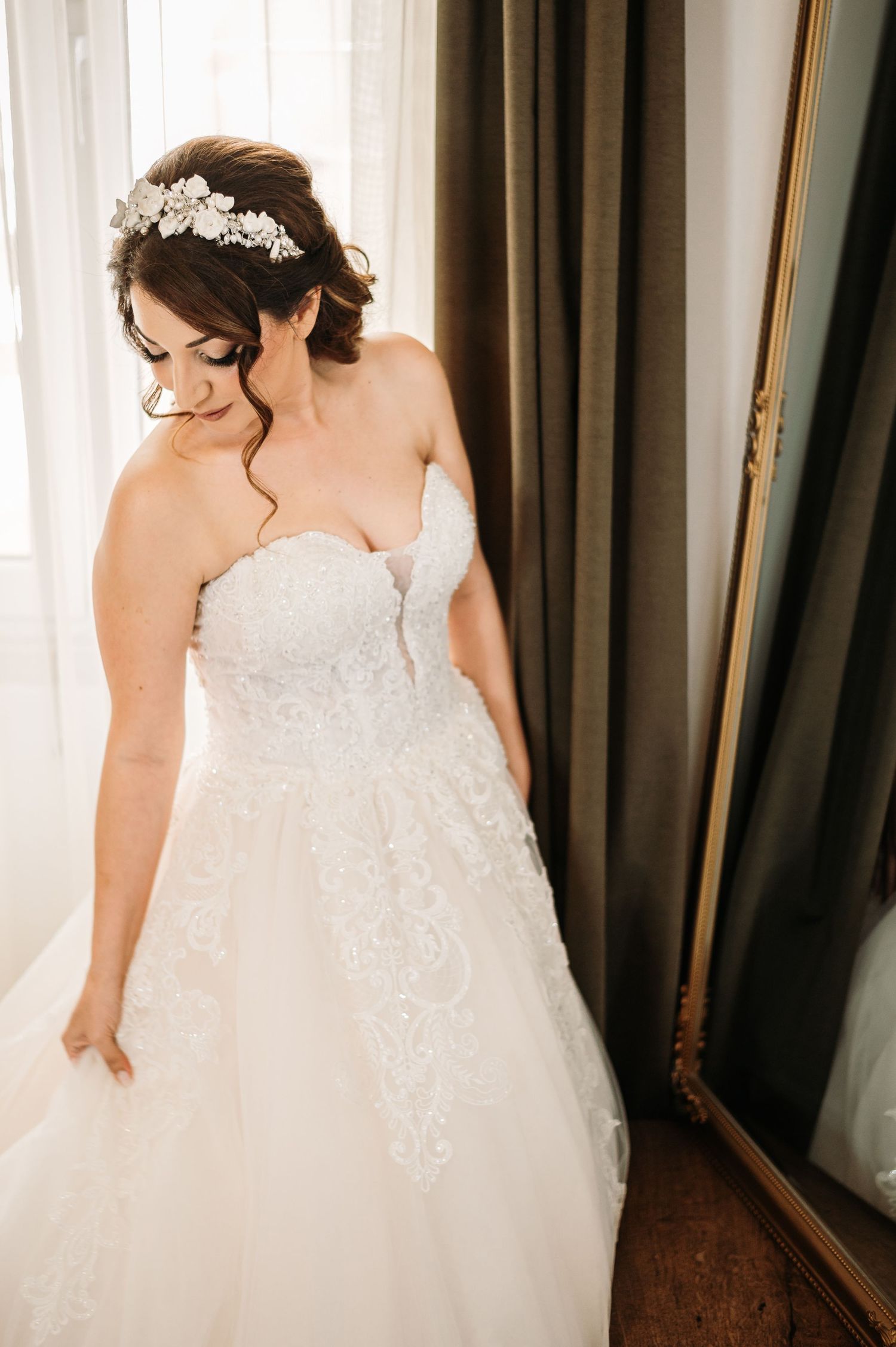 Wedding dress details showing intricate lace and beadwork in natural light.
