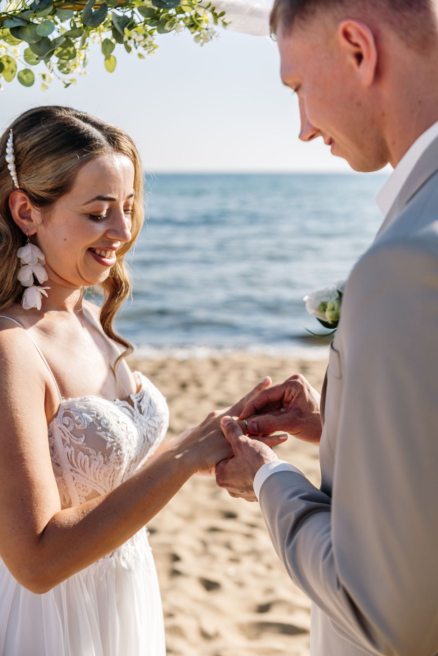 Close-up shots of ring exchange during seaside wedding ceremony.