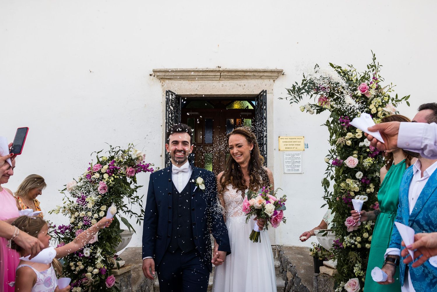 Outdoor wedding venue decorated with pink floral arrangements and greenery.