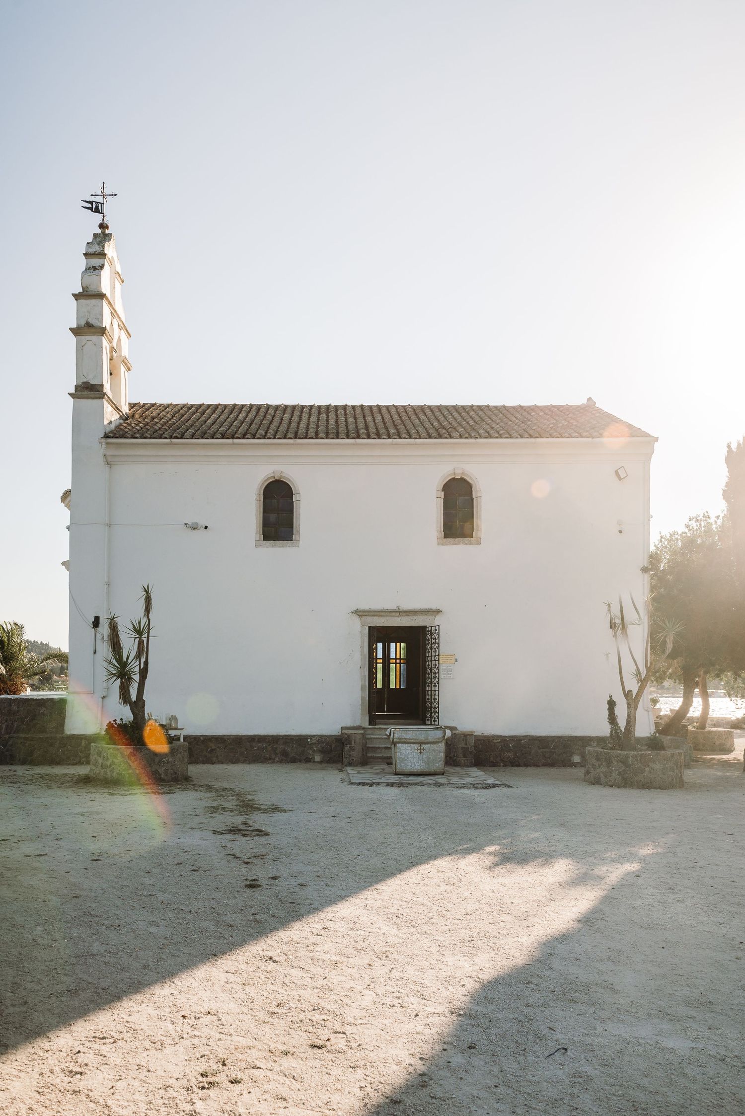 A white Mediterranean church exterior photographed at sunset with beautiful natural lighting.