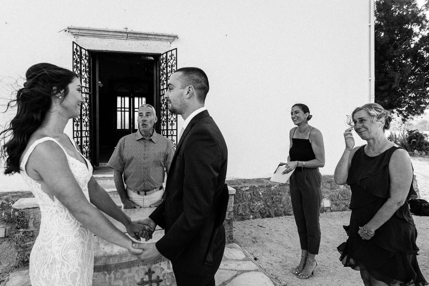 A couple laughs together during their seaside wedding celebration.