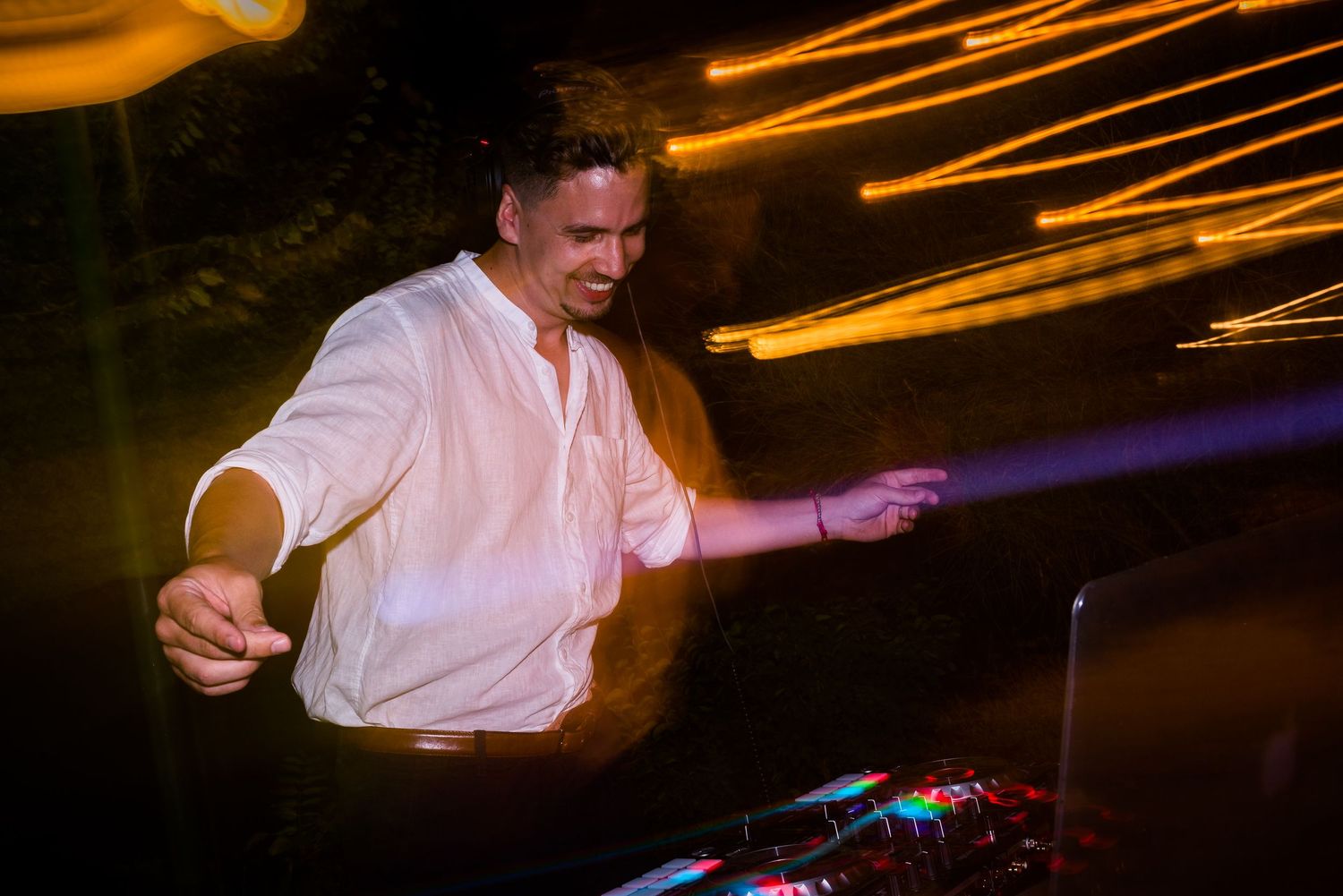 Motion-blurred dance moves captured under dramatic lighting at wedding reception.