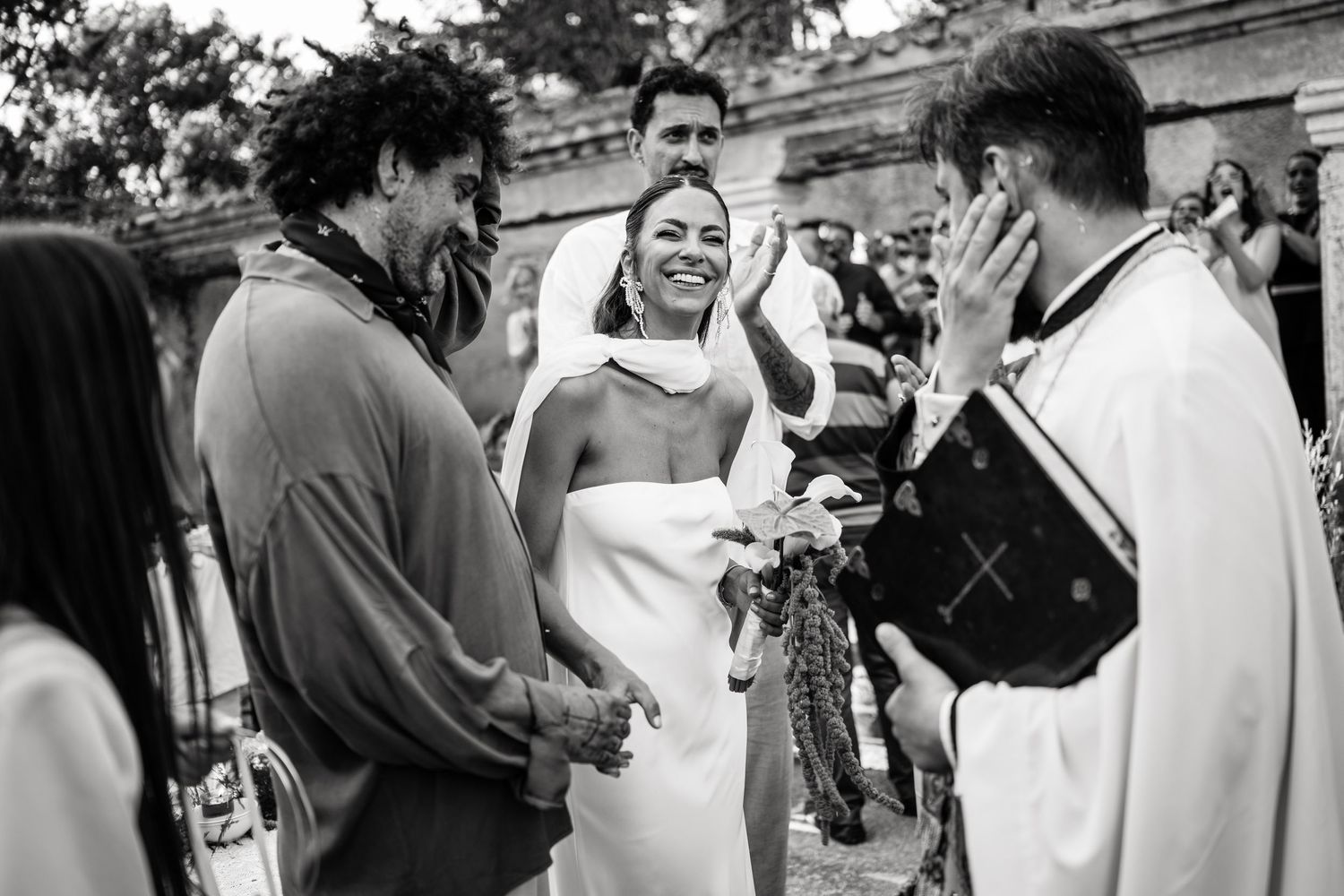Wedding guests gather in casual conversation during an outdoor celebration.