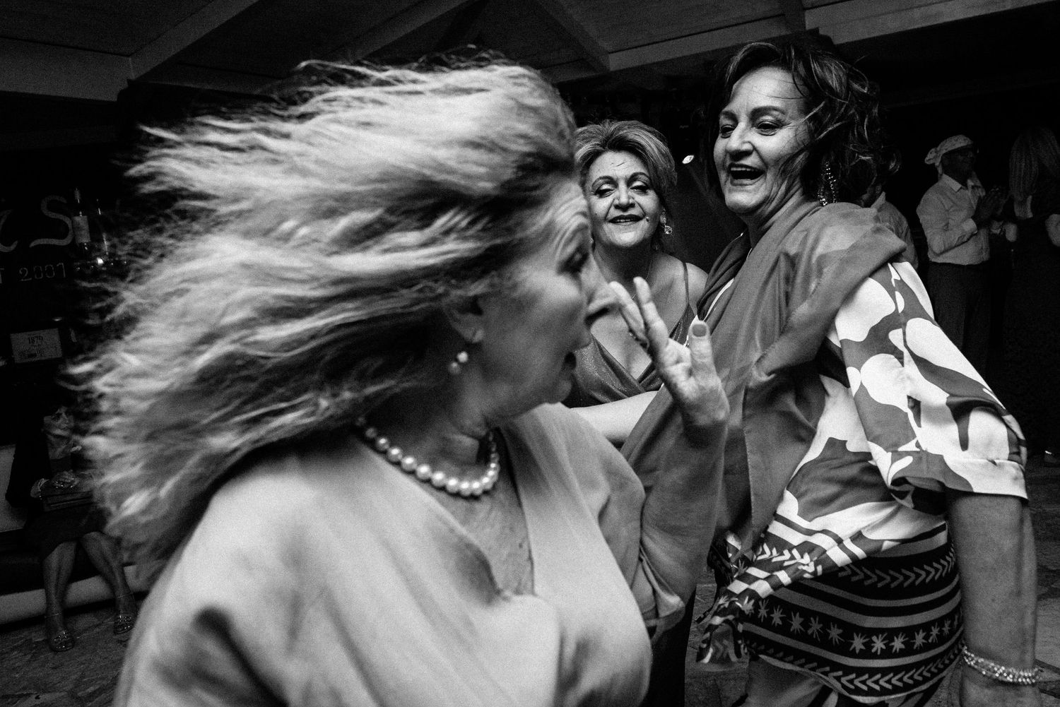 Energetic dancers with flowing hair captured in dynamic black and white photography.