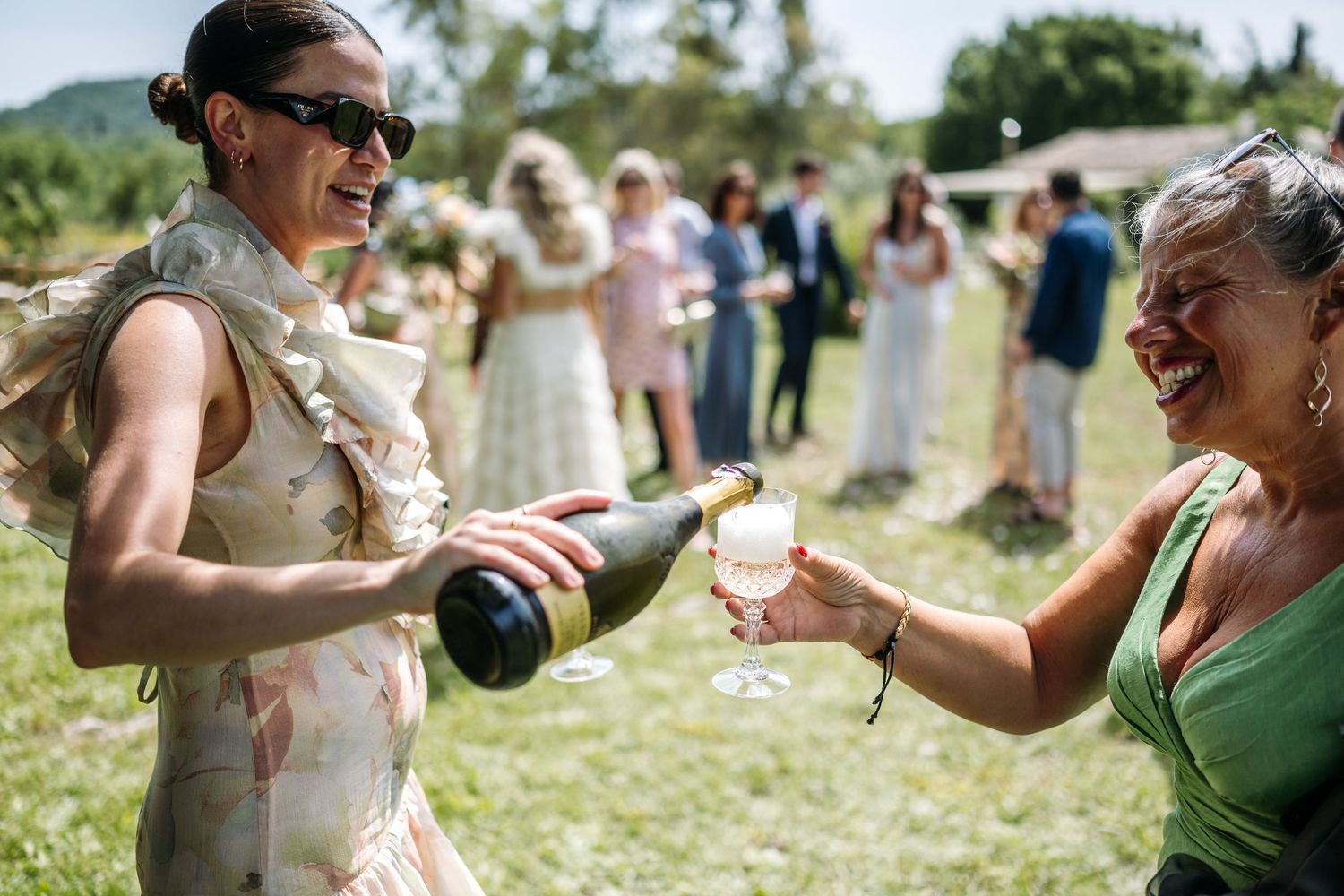 Guests raise glasses in a joyful outdoor wedding celebration.