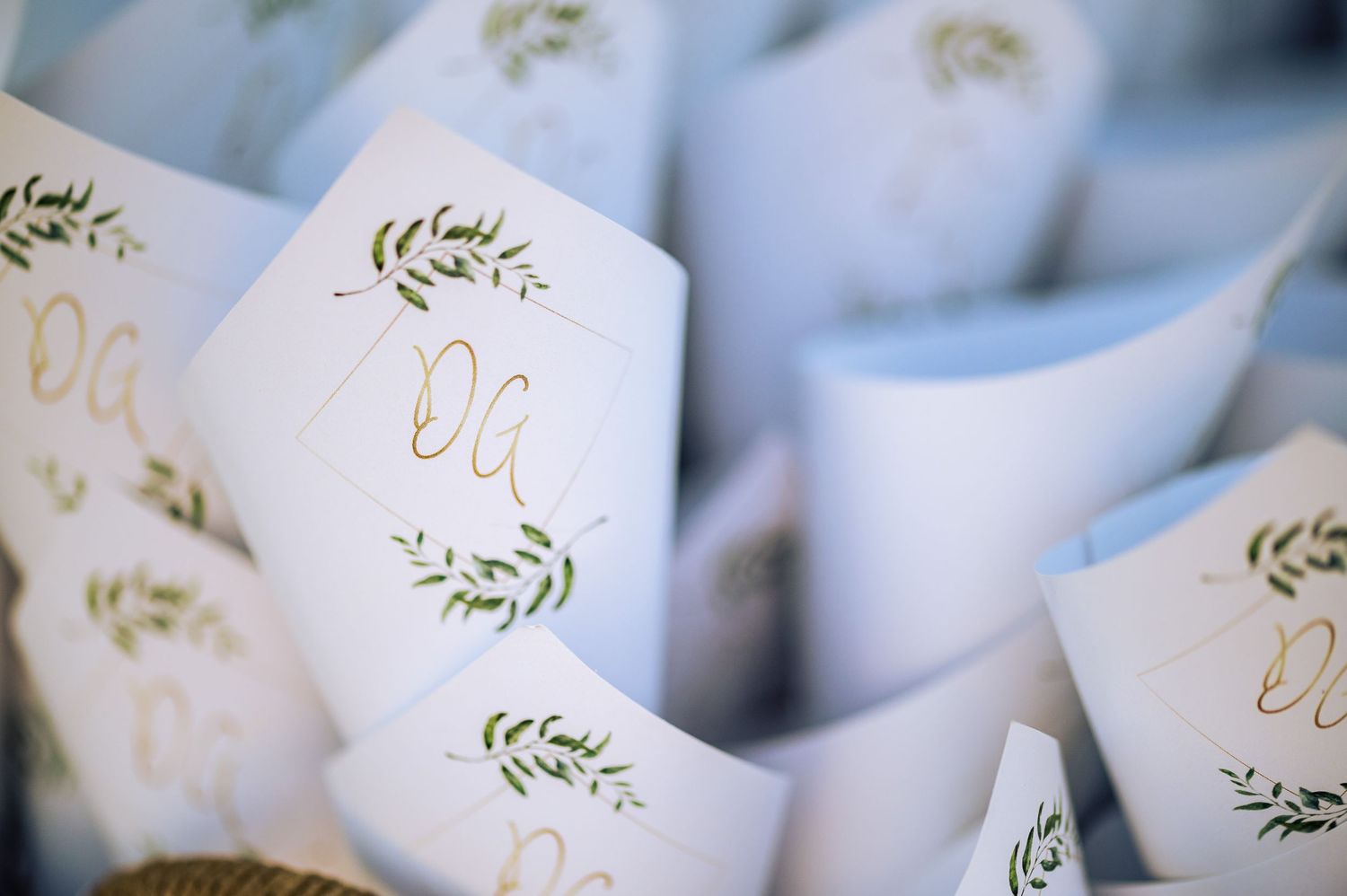 Elegant white paper place cards with delicate green floral designs.