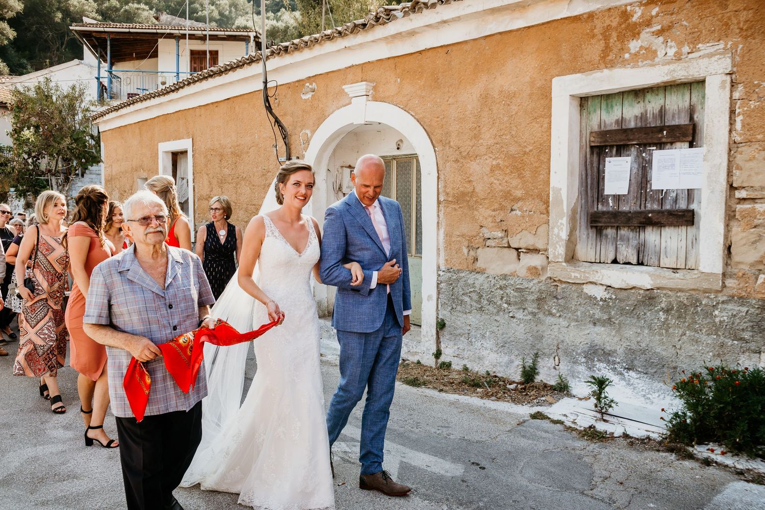 Wedding celebration on a rustic street with old world architecture and stone walls.
