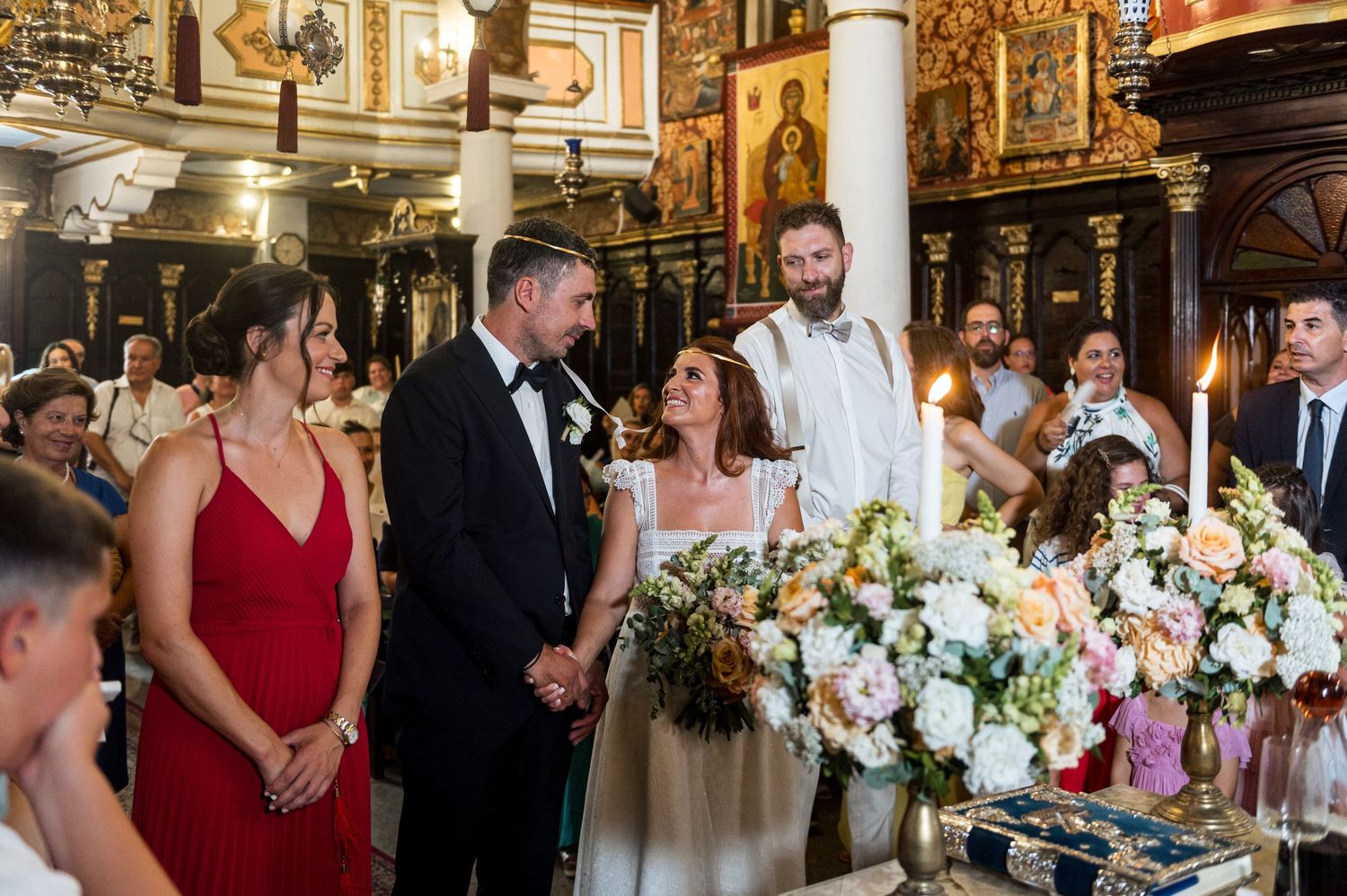 Wedding reception in an elegant hall with white columns and floral centerpieces.