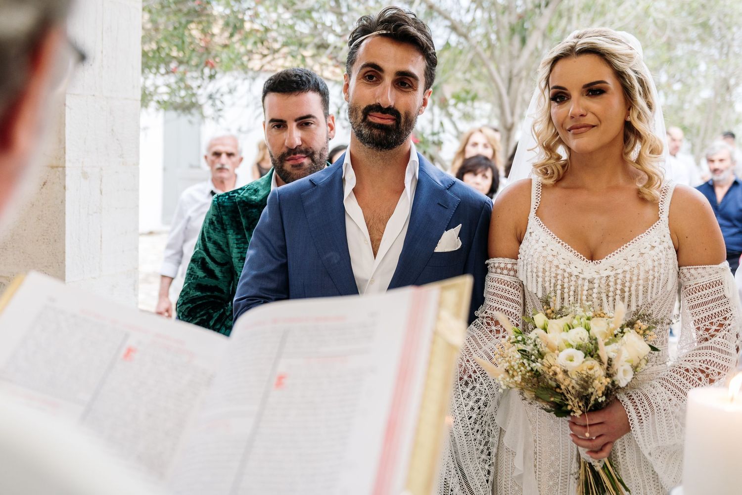 Elegant destination wedding celebration with guests under Mediterranean architecture.